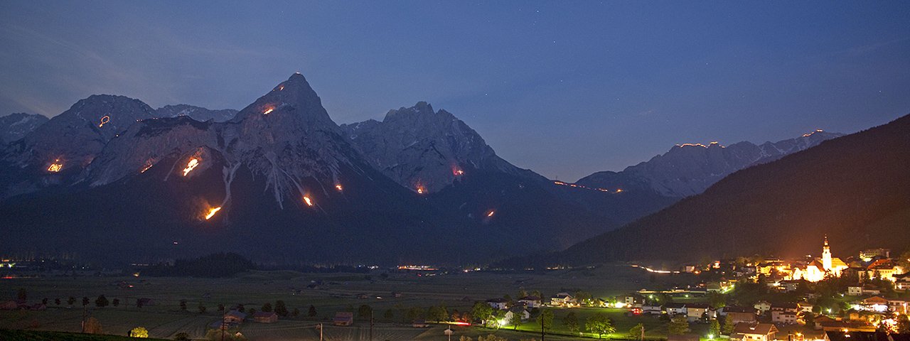 Im Talkessel von Ehrwald bietet sich ein freier Blick auf die vielen Sonnwendfeuer in der Tiroler Zugspitz Arena, © Albin Niederstrasser