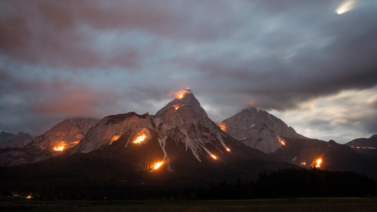 Im breiten Talkessel von Ehrwald sind die Bergfeuer zu Mittsommer ein echter Höhenpunkt. An den Hängen der Ehrwalder Sonnenspitze und der Zugspitze leuchten die facettenreichen feurigen Motive bis zum Talboden herab., © Oliver Soulas