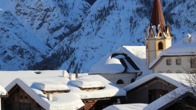 Landhaus mit Pfleghaus und Kirche im Winter