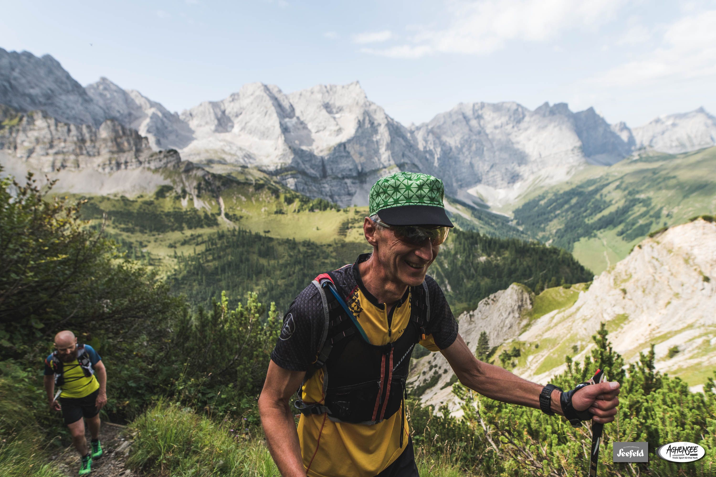 zwei Teilnehmer in sportlichem Wanderoutfit, im Hintergrund Felsberge des Karwendels