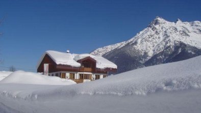 Wanderweg mit Blick zum Haus im Tiefschnee