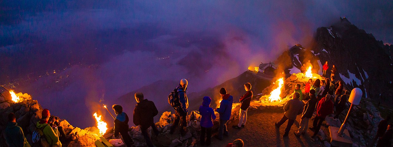 Andächtige Stimmung bei den Sonnwendfeuern auf der Nordkette hoch über Innsbruck, © Webhofer / W9 Werbeagentur