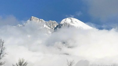 Verschneite Berge ragen aus dem Nebel