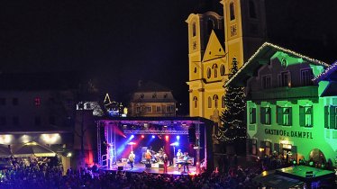 Farbenfroh illuminiert und mit Konzertbühne zeigt sich der Hauptplatz in St. Johann bei der Silvester Warm Up Party, © Werner Krepper