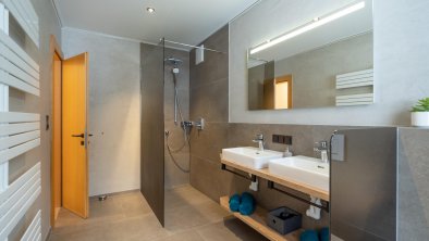 großzügige Walk-in-Dusche mit Doppelwaschbecken