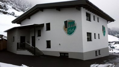 Ansicht Haus Luigi mit Haupteingang und Parkplatz