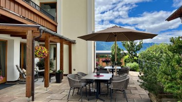 Terrasse mit Tischen und Stühlen